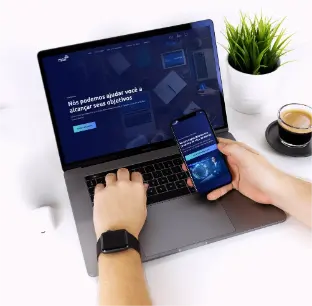 uma imagem de um desktop e um mobile em cima de uma mesa.